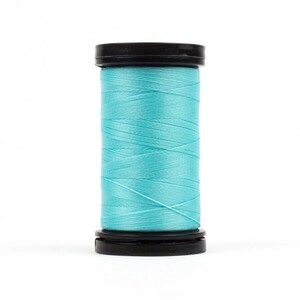 May include: A spool of turquoise blue thread wound on a black plastic bobbin.