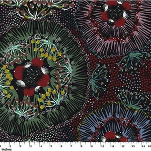 May include: A fabric with a repeating floral pattern in shades of red, green, yellow, and white on a black background. The design features circular floral motifs with intricate details, including dotted accents and leaf-like shapes. The image includes a ruler with inches.