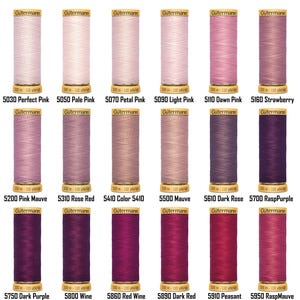Puede incluir: Una colección de carretes de hilo Gütermann en varios tonos de rosa y morado. Los carretes están etiquetados con nombres y números de color, incluyendo Perfect Pink, Pale Pink y Dark Purple. Cada carrete contiene 100 metros de hilo.