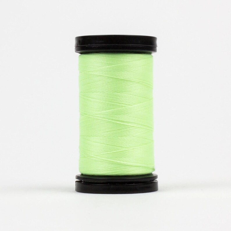 May include: A spool of light green thread with black plastic caps on either end.