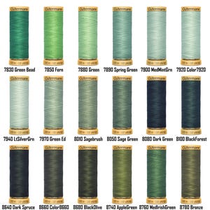 Könnte beinhalten: Eine Sammlung von Gütermann-Garnrollen in verschiedenen Grüntönen. Die Spulen sind mit Farbnamen und -nummern beschriftet, darunter "Green Bead", "Fern" und "Dark Spruce". Jede Spule enthält etwa 100 Meter Garn.
