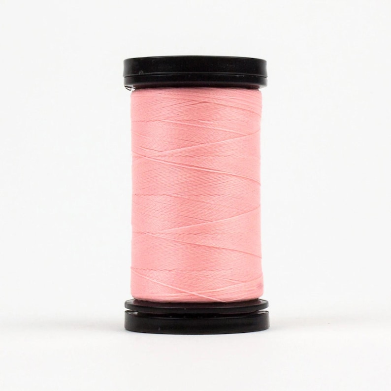 May include: A spool of pink thread with black plastic ends.