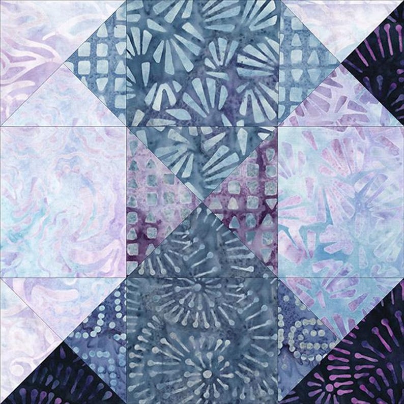 May include: A quilt block with a geometric pattern made from different shades of blue and purple fabric. The fabric has a variety of patterns, including swirls, dots, and geometric shapes.