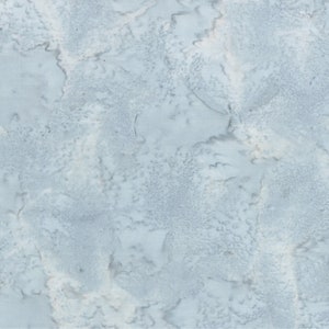 May include: A light blue fabric with a mottled pattern. The design features areas of lighter and darker shades of blue, creating a textured, watercolor-like effect. The fabric appears to be cotton or a similar material, suitable for quilting or apparel.