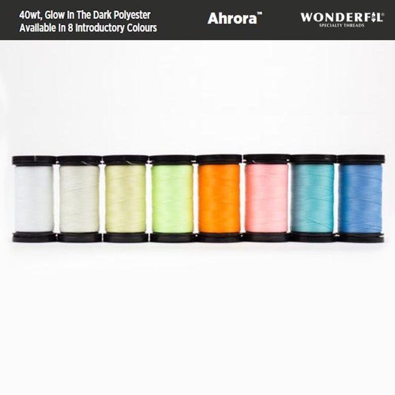 May include: Eight spools of 40wt glow-in-the-dark polyester thread in various colors, including white, light green, yellow, orange, pink, blue, and light blue. The spools are labeled "Ahrora&trade; WONDERFIL SPECIALTY THREADS".