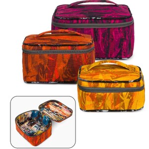 May include: Three colorful cosmetic bags with a zipper closure and a top handle. The bags are made of a patterned fabric with a geometric design. The bags are open and empty.