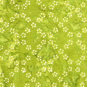 May include: A green fabric with a batik pattern. The design features small, white, four-petal flower shapes scattered across the surface. The background has a mottled appearance with shades of green and yellow.