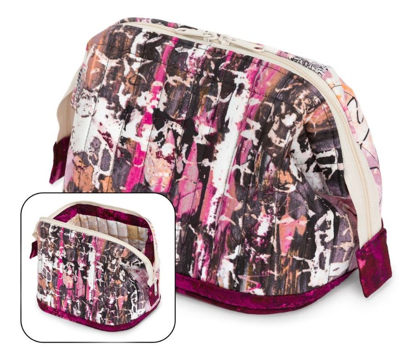 May include: A quilted makeup bag with a pink, brown, and white abstract print. The bag has a zipper closure and a burgundy velvet trim.