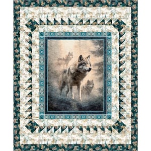 May include: A decorative quilt featuring a central image of wolves in a misty forest. The quilt has a teal and cream border with geometric patterns and a detailed frame around the wolf image. The overall design evokes a nature theme.