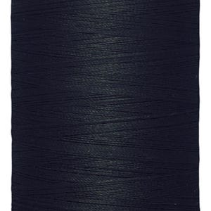 May include: A spool of dark navy blue Gütermann sewing thread. The white top label features the brand name Gütermann, and the white bottom label displays the length as 1000 m - 1094 yds/vgs. The thread is wound tightly around the cylindrical spool.
