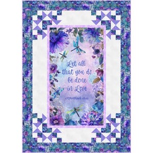 Puede incluir: Un edredón floral con un panel central con el texto "Let all that you do be done in Love". El panel está rodeado de flores moradas, libélulas y un borde blanco con patrones geométricos. Los bordes del edredón están adornados con un diseño floral.