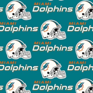 May include: A repeating pattern featuring the Miami Dolphins logo and helmet on a teal background. The logo includes a dolphin leaping through a sun, and the helmet is white with teal and orange accents. The text "MIAMI Dolphins" is also present.