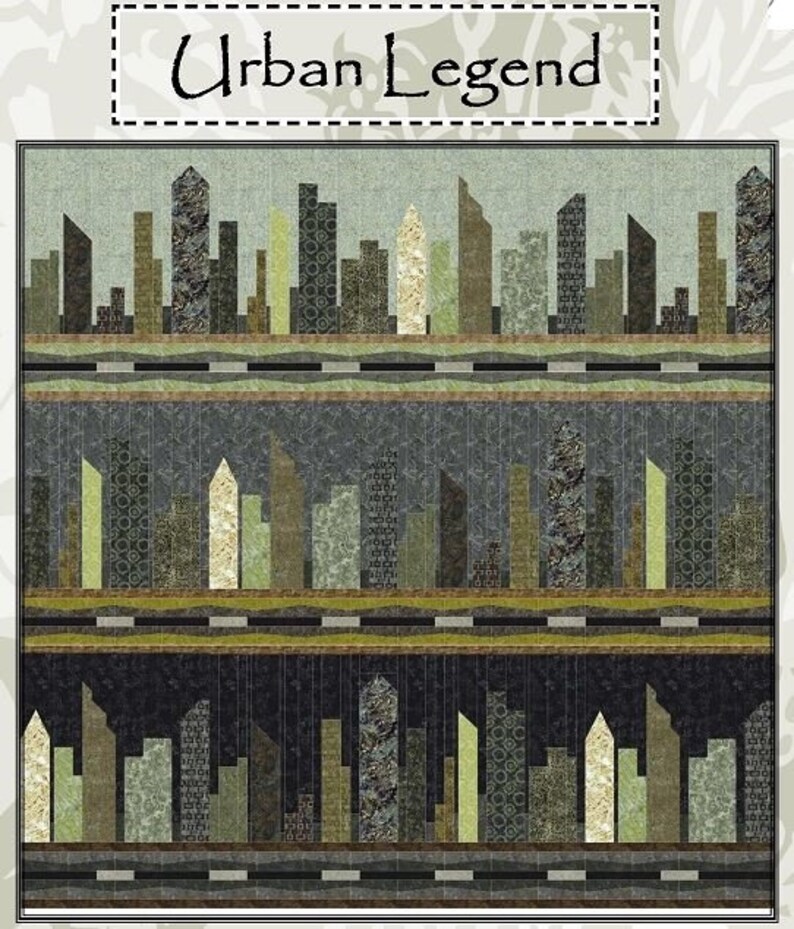 May include: A fabric quilt with a cityscape design. The quilt features a repeating pattern of stylized buildings in shades of green, brown, and beige. The text "Urban Legend" is at the top of the quilt.