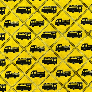 May include: A repeating pattern of black fire trucks on a bright yellow background. The design is arranged in a diamond grid with dashed lines, creating a textured appearance. The fire trucks have ladders and are in a simple silhouette style.