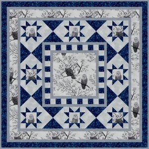 May include: A square quilt featuring a repeating owl and tree design in shades of blue, gray, and white. The quilt has a central square with owls perched on branches, surrounded by star and diamond patterns. The border is a dark blue floral print.