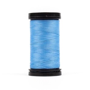 May include: A spool of light blue thread with a black plastic top and bottom.
