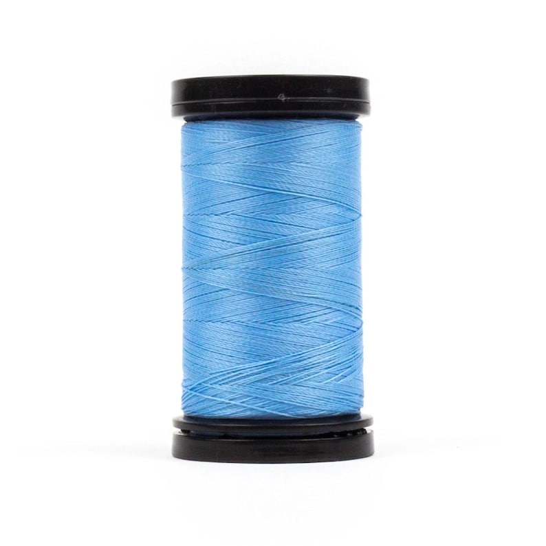 May include: A spool of light blue thread with a black plastic top and bottom.