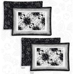 May include: Black and white pillow with a geometric pattern on the front and a floral pattern on the back. The pillow is shown on a white background with a floral pattern.