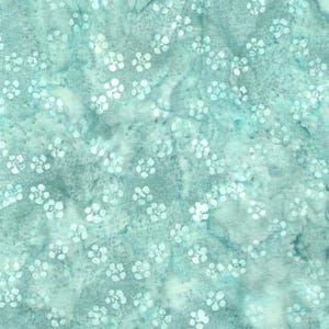 May include: A teal and grey fabric with a watercolour effect. The pattern features small, white, flower-like shapes scattered across the surface. The fabric has a mottled appearance, with variations in colour and texture.
