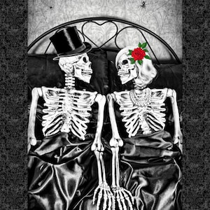 May include: A black and white image of two skeletons in bed. One skeleton wears a top hat, the other has a red rose in its hair. They are lying on black satin sheets, with a decorative headboard and a spider web in the background.