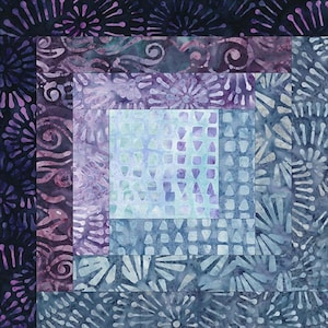 May include: A quilt block with a log cabin pattern in shades of blue and purple. The center of the block is a light blue square with a geometric pattern. The outer layers of the block feature a variety of floral and swirl patterns.