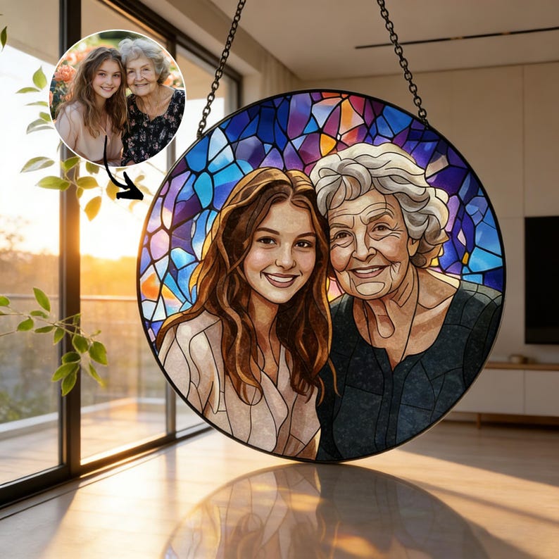 May include: A round stained glass art piece featuring a portrait of two women. The artwork has a black border and is suspended by a chain. The background is a mosaic of blue, purple, and orange hues, with the women's faces in the center.