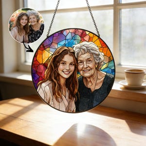 May include: A round stained glass window with a photo of two women, one young and one older, hanging from a chain. The background is a mosaic of colorful geometric shapes. A smaller photo of the women is in the upper left corner.