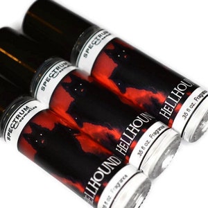 May include: Three black roll-on bottles with a red and black label featuring a black dog silhouette. The label reads "SPECTRUM cosmetics" and "HELLHOUND Fragrance 0.35 fl oz."
