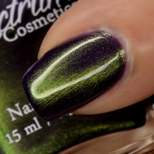 May include: A bottle of green and purple nail polish with a magnetic effect. The bottle is labeled "Spectrum Cosmetics" and "15 ml".