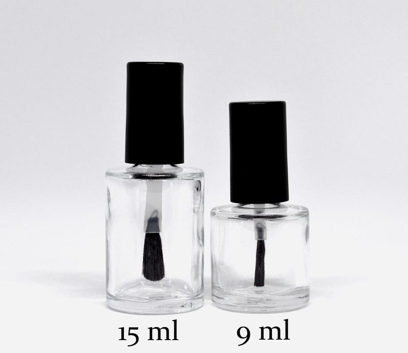 May include: Two clear glass bottles with black caps and brushes. The bottle on the left is labelled 15 ml and the bottle on the right is labelled 9 ml.