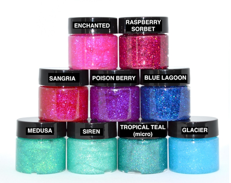 May include: A set of ten small jars of glitter glue in various colors, including pink, red, purple, blue, teal, and green. The jars are labeled with names like "Enchanted", "Raspberry Sorbet", "Sangria", "Poison Berry", "Blue Lagoon", "Tropical Teal", "Medusa", "Siren", and "Glacier".