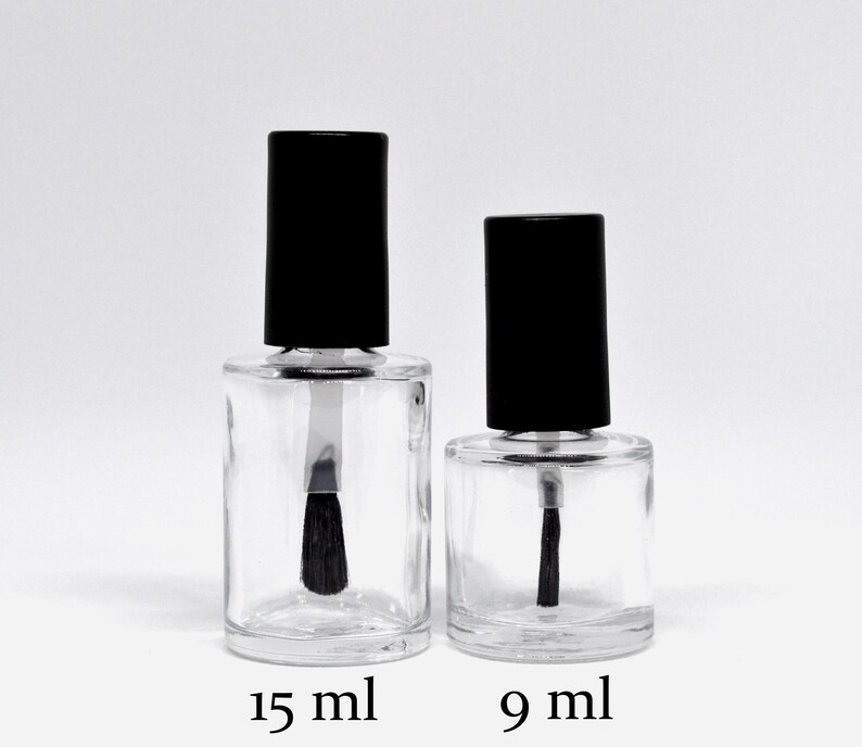 May include: Two clear glass bottles with black caps and brushes. The bottle on the left is labeled "15 ml" and the bottle on the right is labeled "9 ml".