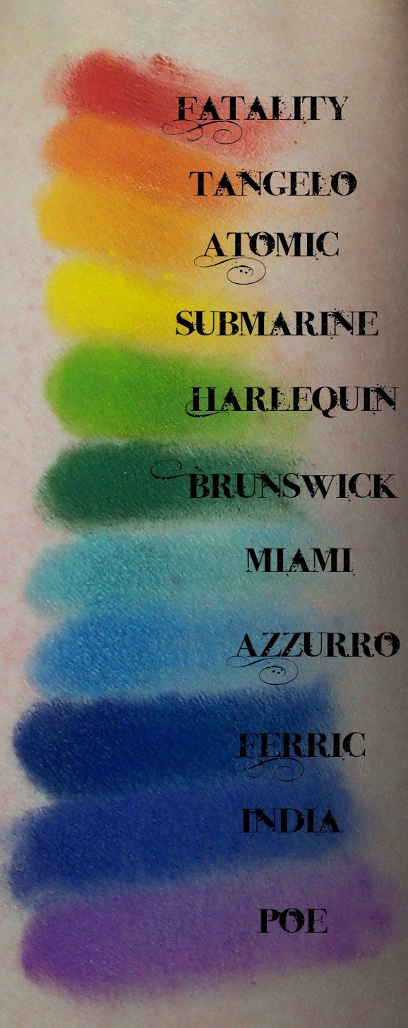 May include: A close-up of a makeup palette with 10 eyeshadows. The eyeshadows are arranged in a vertical row, with the names of each shade printed below them. The shades are: Fatality, Tangelo, Atomic, Submarine, Harlequin, Brunswick, Miami, Azzurro, Ferric, and Poe.