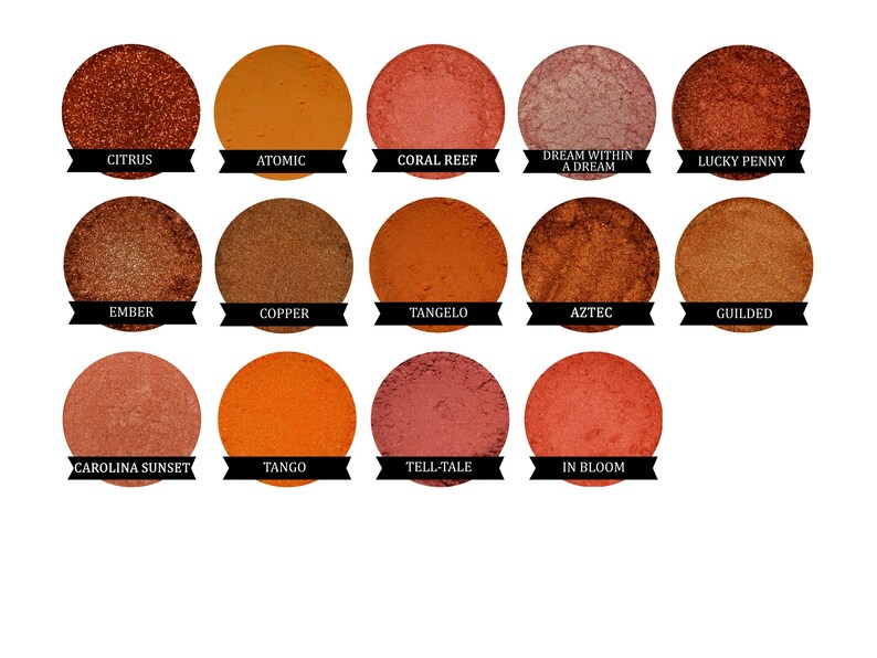 May include: A collection of 15 round eyeshadows in various shades of orange, red, and brown. The eyeshadows are arranged in three rows of five. Each eyeshadow has a name printed below it.