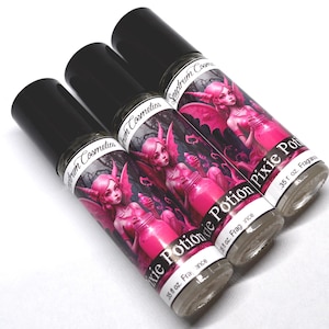 May include: Three 0.35 fl oz bottles of Pixie Potion fragrance oil. Each bottle features a black and white illustration of a pink fairy with wings holding a jar of pink potion. The bottles are labeled "Pixie Potion" and "Spectrum Cosmetics".