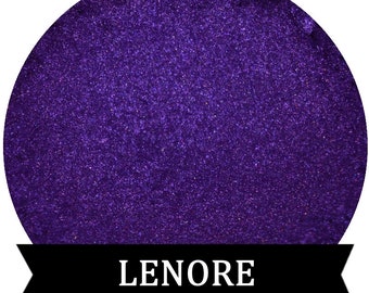 May include: A close-up of a deep purple fabric with a shimmery, glittery texture. The fabric has the word "LENORE" printed in white on a black ribbon.