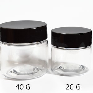 May include: Two clear plastic jars with black lids. The larger jar is labeled "40 G" and the smaller jar is labeled "20 G".