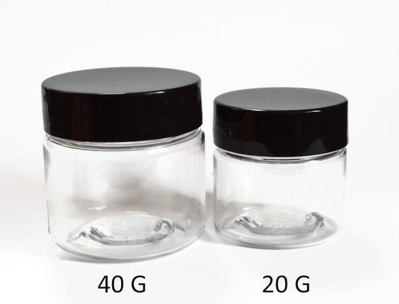 May include: Two clear plastic jars with black lids. The larger jar is labeled "40 G" and the smaller jar is labeled "20 G".