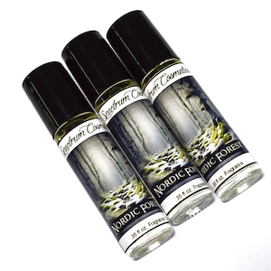 May include: Three glass roll-on bottles with black caps and labels that say "Spectrum Cosmetics" and "Nordic Forest" with a snowy forest scene. Each bottle contains 0.35 fl oz of fragrance.