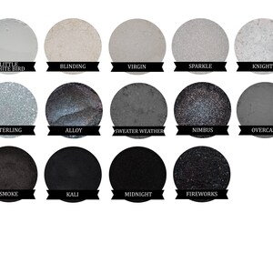 May include: A palette of 14 eyeshadows in various shades of gray, black, and white. The names of the eyeshadows are listed below each color: Little White Bird, Blinding, Virgin, Sparkle, Knight, Sterling, Alloy, Sweater Weather, Nimbus, Overcast, Smoke, Kali, Midnight, and Fireworks.