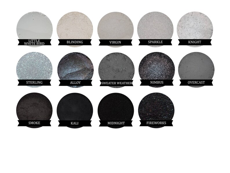 May include: A palette of 14 eyeshadows in various shades of gray, black, and white. The names of the eyeshadows are listed below each color: Little White Bird, Blinding, Virgin, Sparkle, Knight, Sterling, Alloy, Sweater Weather, Nimbus, Overcast, Smoke, Kali, Midnight, and Fireworks.