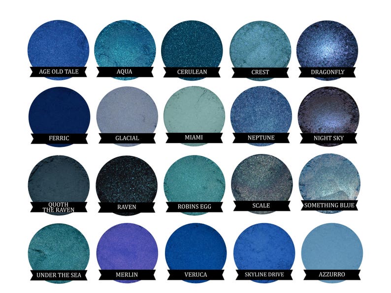 May include: A collection of 15 blue and green eyeshadows in round pans. The eyeshadows are arranged in a grid of five rows and three columns. The names of the eyeshadows are printed below each pan.