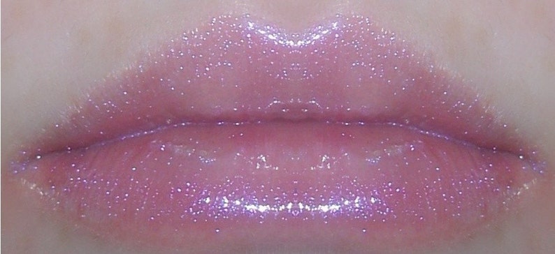 May include: Close-up of a pair of lips wearing a light pink lip gloss with iridescent glitter.