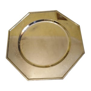 Può includere: Un piatto da portata ottagonale color oro con un'indentazione circolare al centro. Il piatto ha una superficie lucida e riflettente e un design semplice ed elegante. Questo piatto decorativo è adatto per servire cibo.