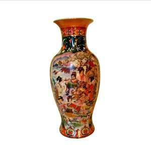 Pu&ograve; includere: Un vaso in ceramica alto e ornato con una base ampia e un bordo svasato. Il vaso presenta una scena dettagliata e colorata di figure in abiti tradizionali, con una tigre ed elementi paesaggistici. Il bordo &egrave; arancione e il collo &egrave; verde scuro.