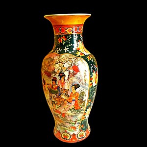 Pu&ograve; includere: Un vaso decorativo con bordo e base svasati. Il vaso presenta una scena dettagliata dipinta a mano di figure e una tigre in un paesaggio. La tavolozza dei colori comprende arancione, verde e oro, con motivi floreali e geometrici.