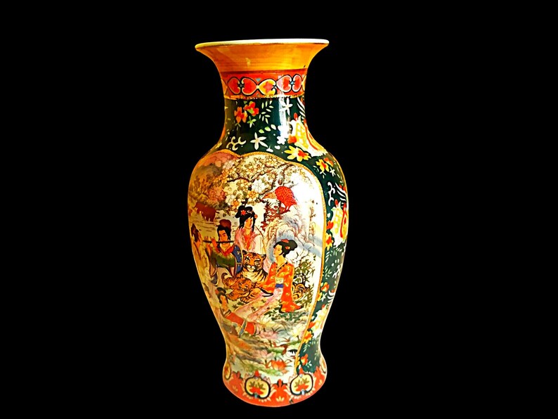Pu&ograve; includere: Un vaso decorativo con bordo e base svasati. Il vaso presenta una scena dettagliata dipinta a mano di figure e una tigre in un paesaggio. La tavolozza dei colori comprende arancione, verde e oro, con motivi floreali e geometrici.