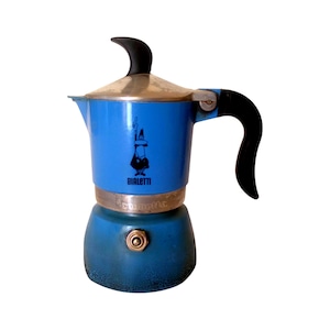 Könnte beinhalten: Eine blaue Bialetti Mokkakanne mit schwarzem Griff und Deckelknopf. Der obere Teil ist leuchtend blau und mit dem schwarzen Bialetti-Logo bedruckt, während der untere Wasserbehälter einen dunkleren Farbverlauf und ein metallenes Ventil aufweist.