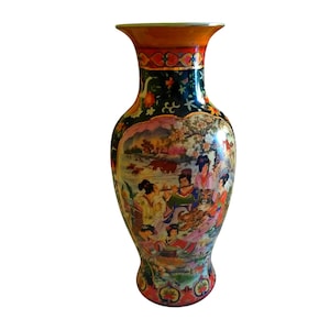 Pu&ograve; includere: Un vaso decorativo in ceramica con bordo svasato e corpo bulboso. Il vaso presenta una scena dettagliata e colorata di figure in un paesaggio. Il bordo &egrave; arancione e rosso, e il corpo &egrave; principalmente verde scuro con disegni floreali e paesaggistici.