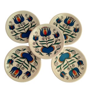 May include: A set of three ceramic mugs with a speckled, matte finish. The mugs are in shades of cream, light gray, and dark gray. Each mug has a simple, minimalist design and a rounded handle.